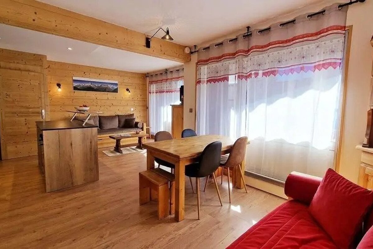 A living room with a red couch , table and chairs