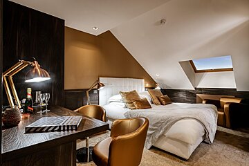 A bottle of champagne sits on a desk in a hotel room