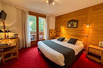 A hotel room with a large bed and a picture on the wall