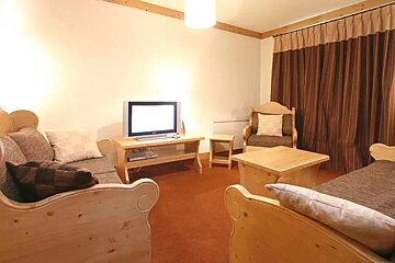 A living room with wooden furniture and a flat screen tv