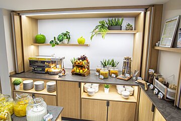 A buffet area with a display of food and a machine that says ' ice cream maker ' on it