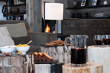 A pitcher of mulled wine sits on a wooden stump