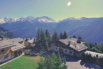 A mountain landscape with a few houses in the foreground