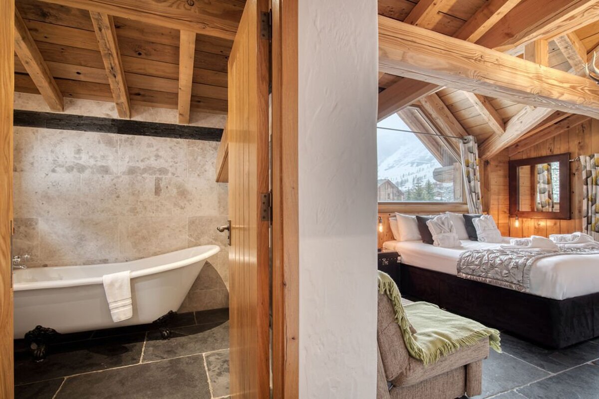 A bedroom with a bathtub and a bed in it