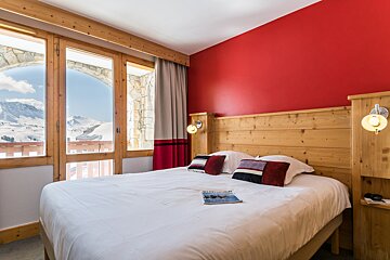 A hotel room with a bed and a magazine on it