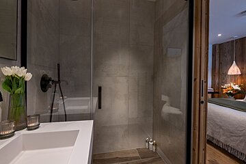 A bathroom with a walk in shower and a sink