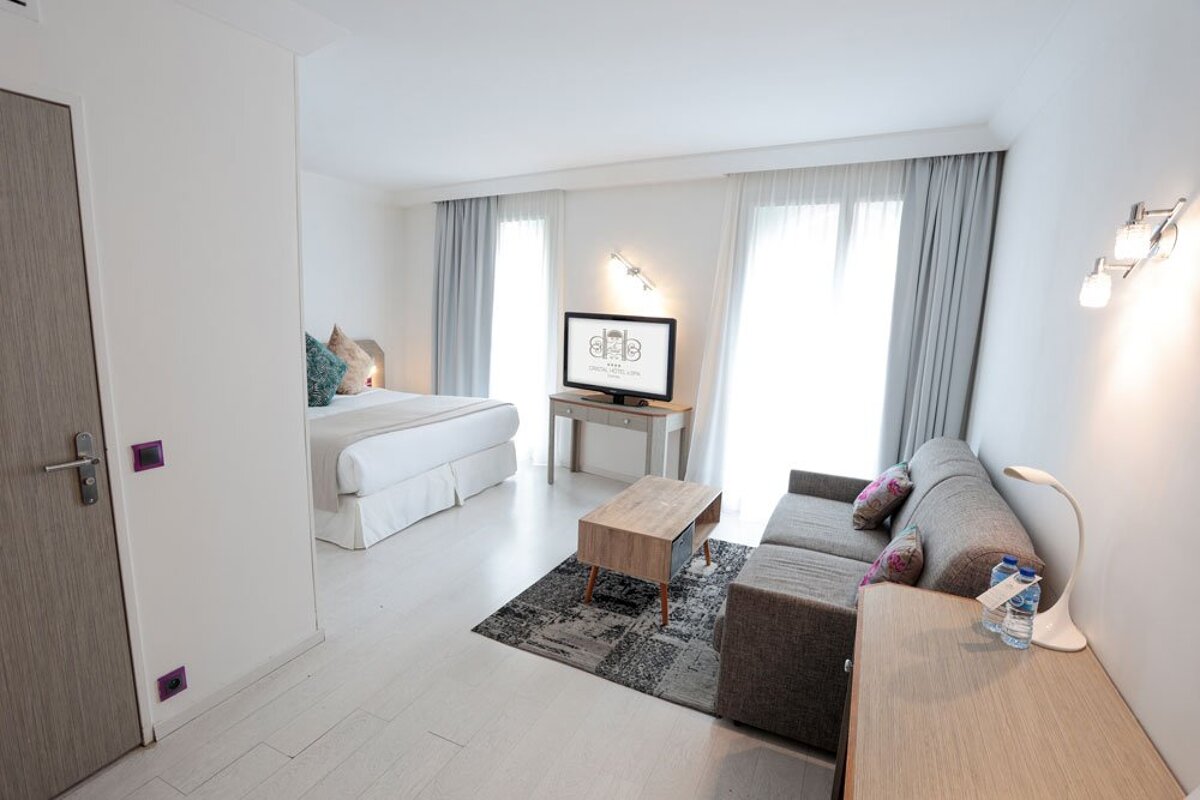 A hotel room with a couch and a flat screen tv