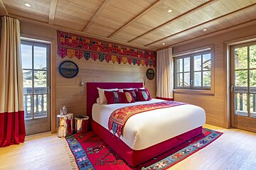 A bedroom with a large bed and a rug