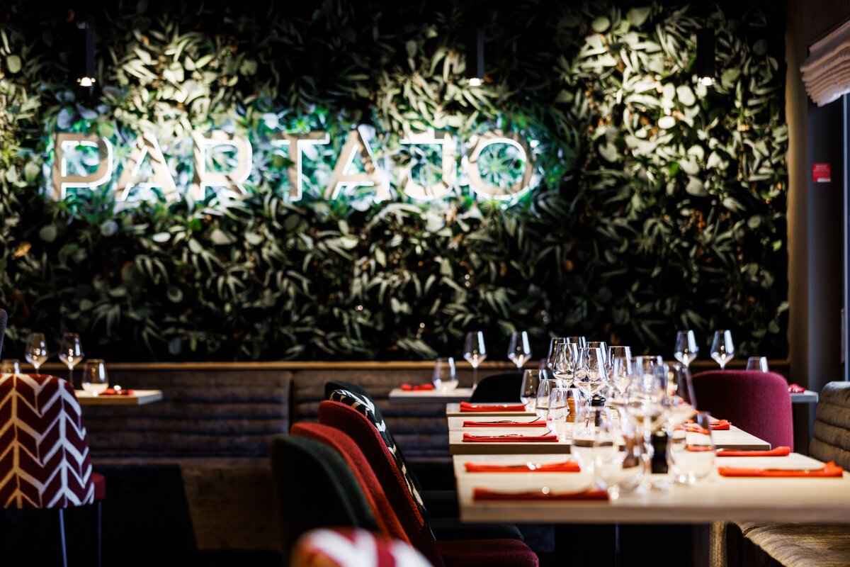 A restaurant with a neon sign that says par tatio