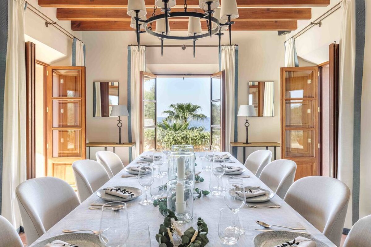 A dining room with a long table and chairs