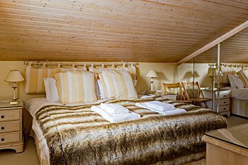 A bedroom with a fur blanket on the bed