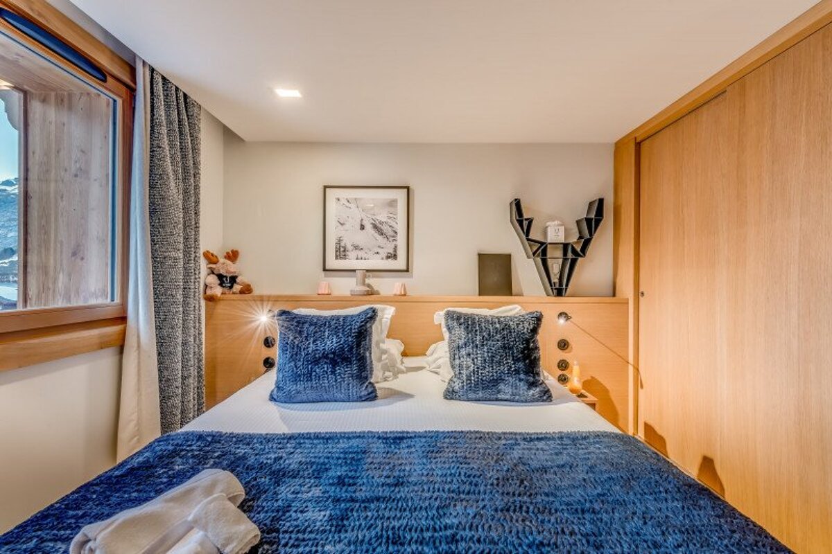 A bedroom with a bed and a picture on the wall