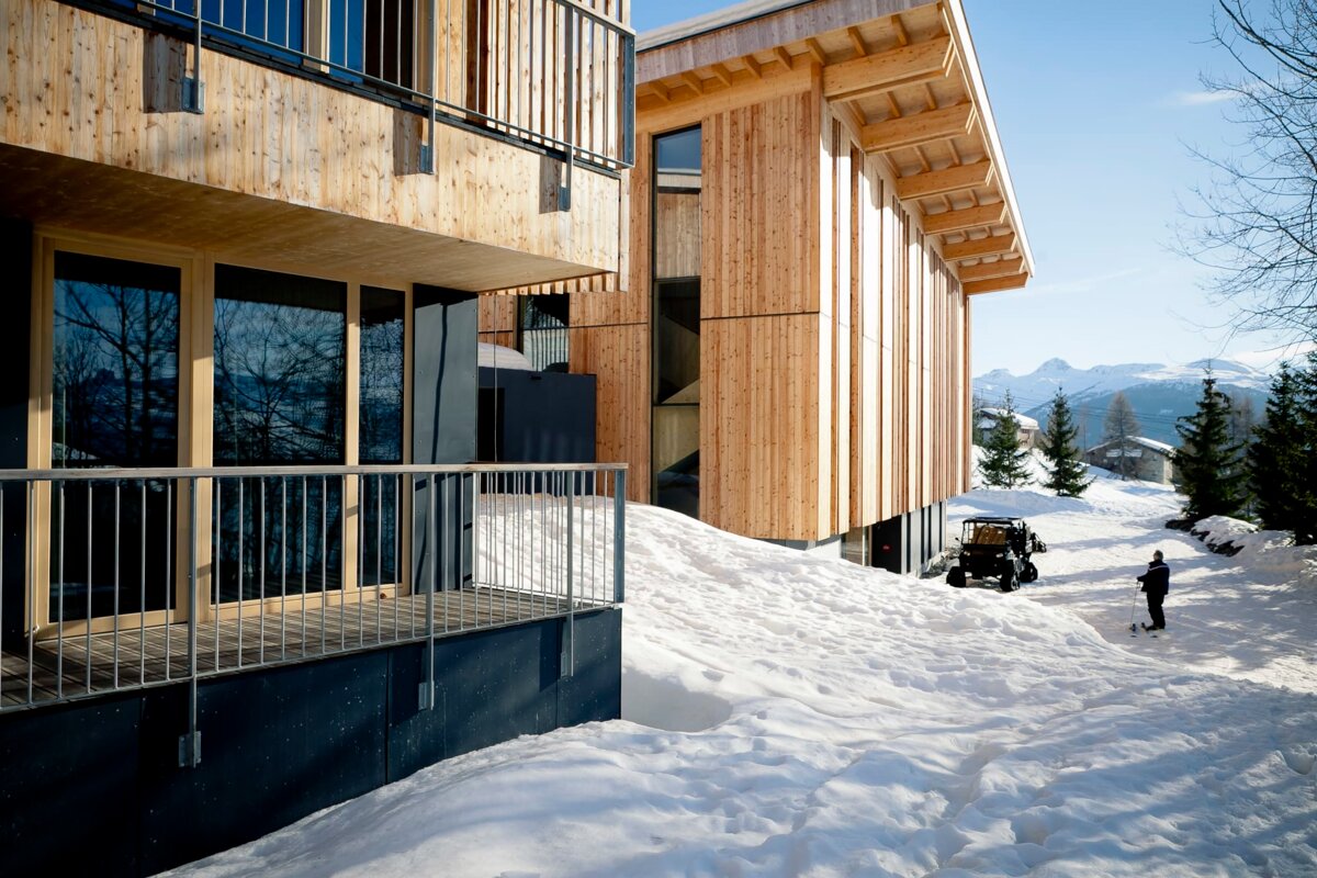 A man standing in the snow near a building