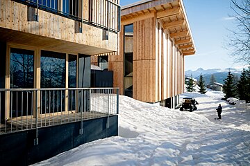 A man standing in the snow near a building