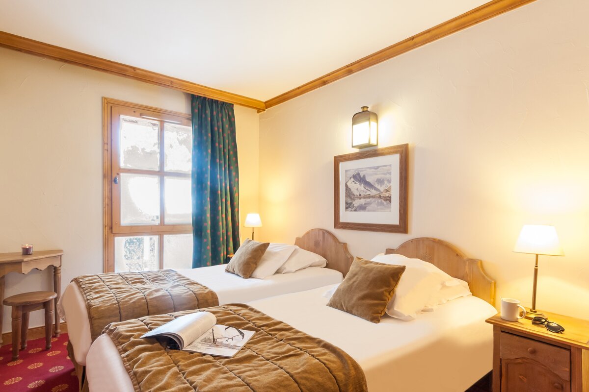 A hotel room with two beds and a picture on the wall