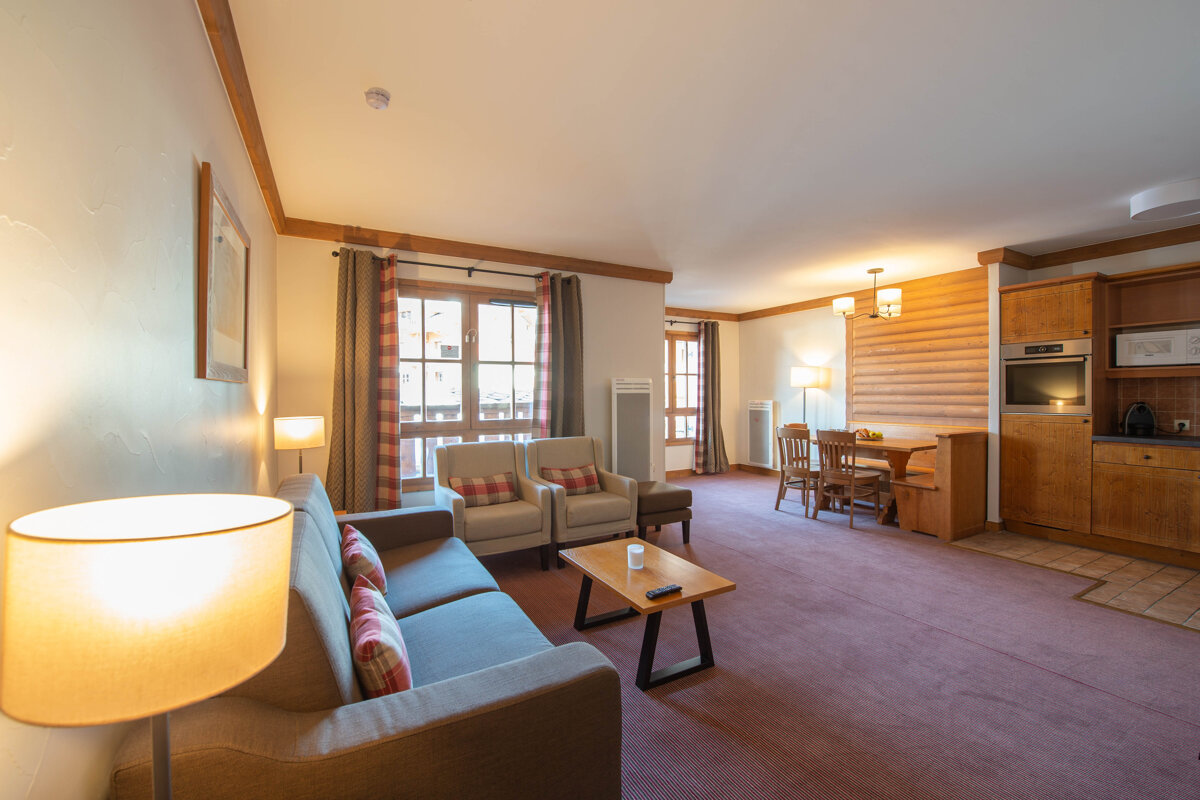 A living room with a couch two chairs and a table