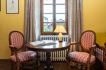 Two chairs sit at a table with an open book on it