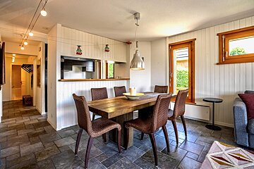 A dining room with a wooden table and chairs