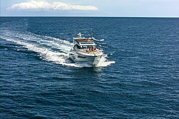 A boat with people on it is floating in the ocean