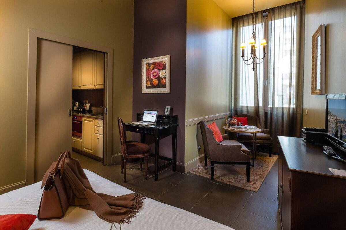 A bedroom with a desk and a laptop on it