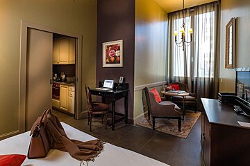 A bedroom with a desk and a laptop on it