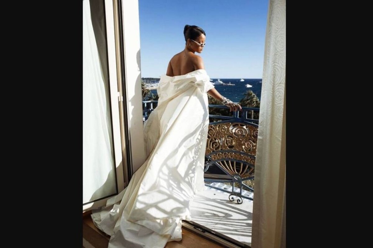 Rihanna in hotel room in white dress