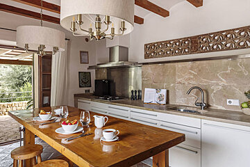 A kitchen with a wooden table and white cabinets
