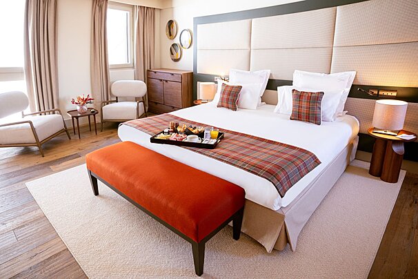 A hotel room with a tray of food on the bed