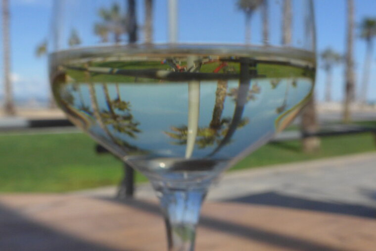 a champagne glass with a view of the sea behind