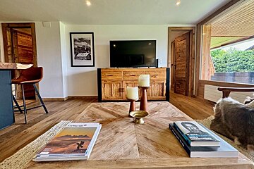 A living room with a wooden table and a tv