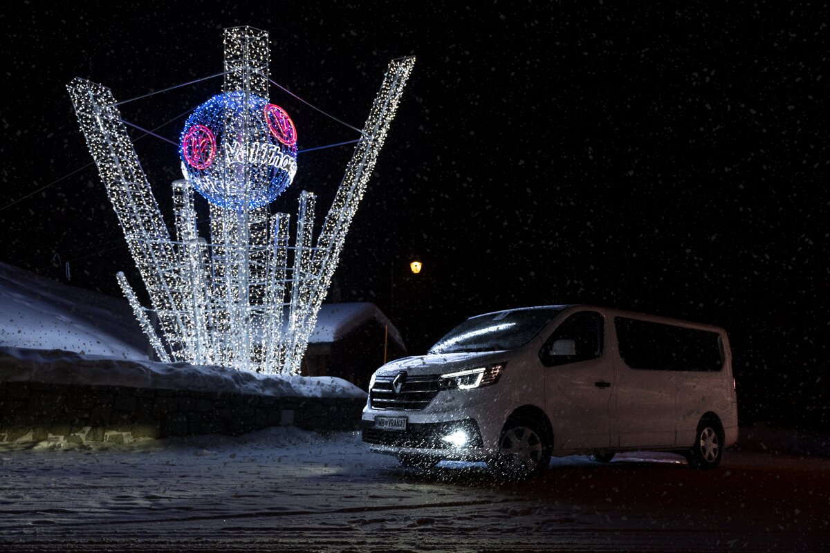 A white van is parked in front of a christmas decoration