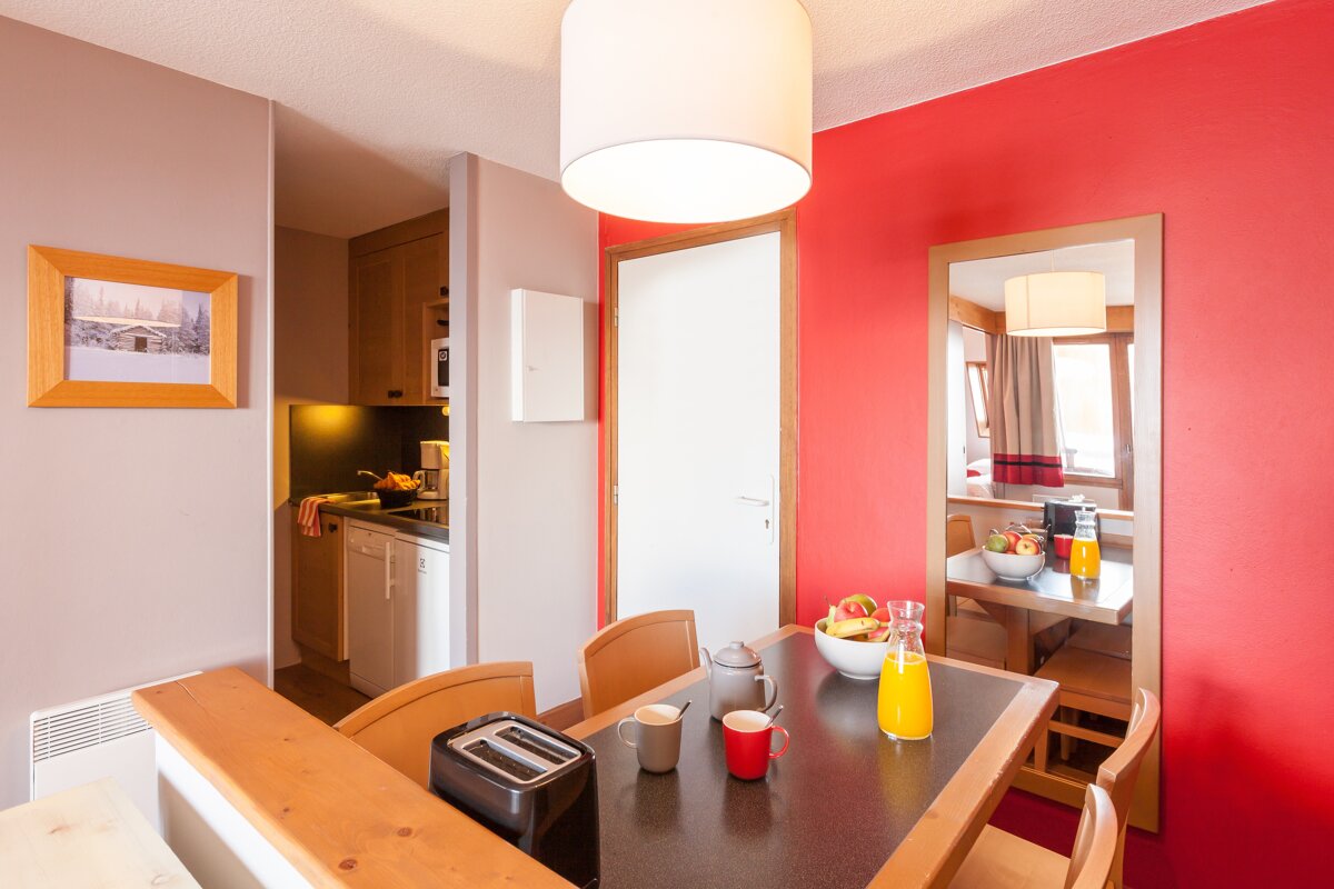 A dining room table with a toaster and cups on it