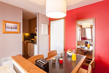 A dining room table with a toaster and cups on it