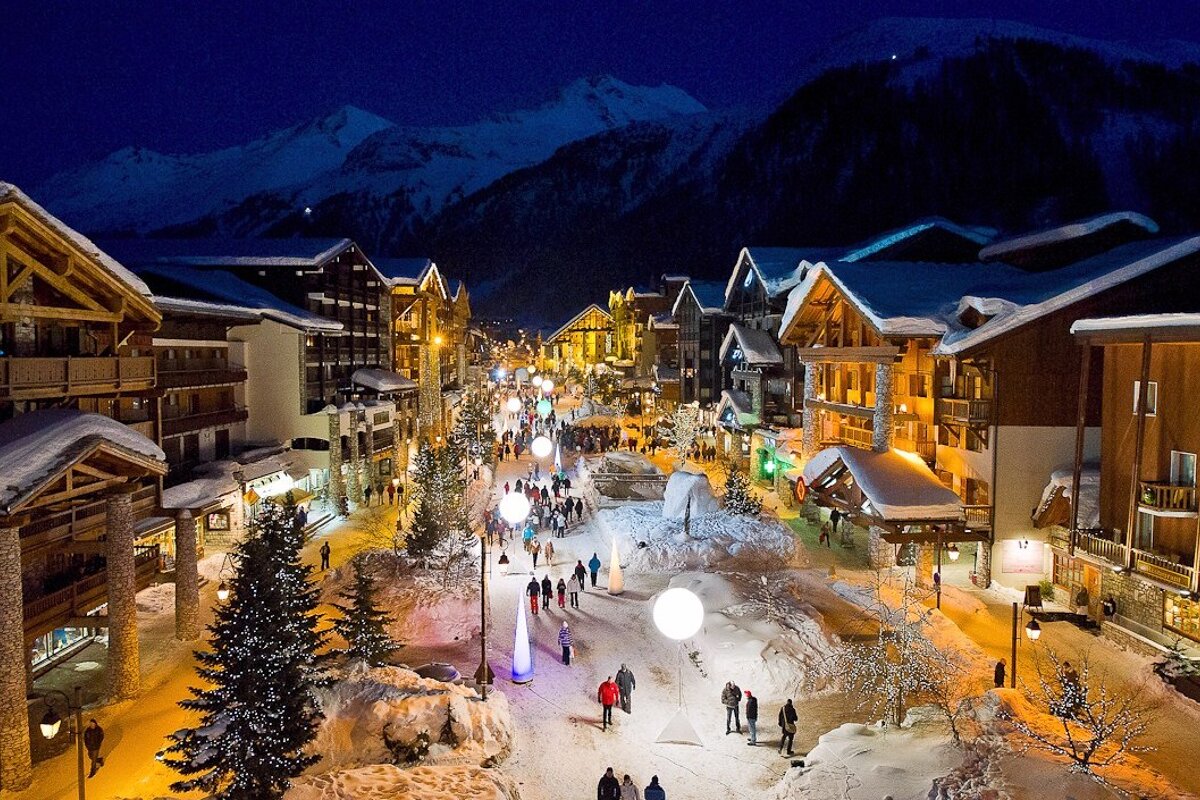 A snowy town at night with mountains in the background
