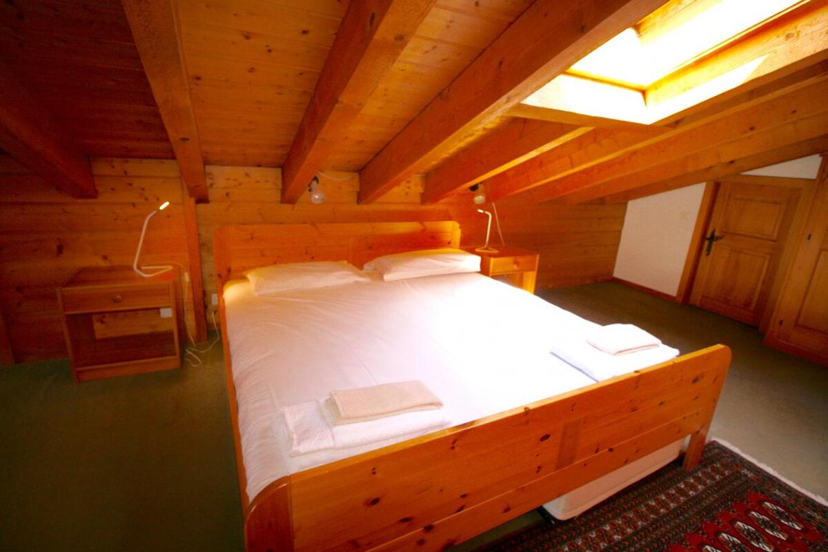 A bedroom with a wooden bed and two nightstands