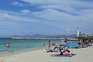 people swimming & sunbathing on can picafort beach