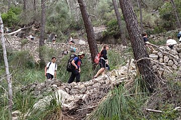 a group of people hiking towards a cave entrance