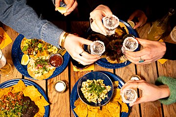 A group of people toasting with shots of tequila