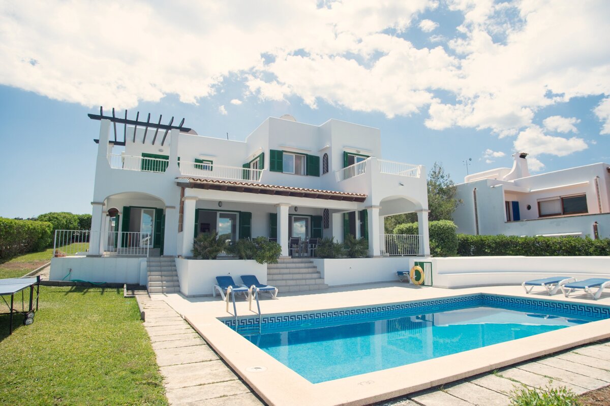 A large white house with a swimming pool in front of it