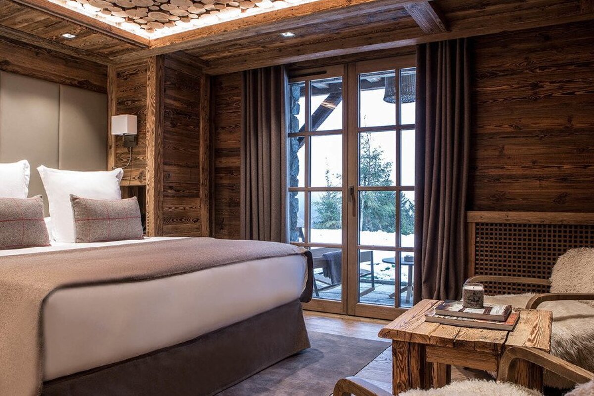 A bedroom with a bed a chair and a table