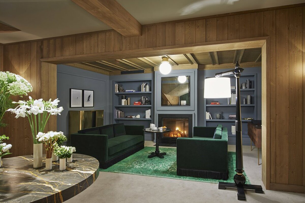 A living room with two green couches and a fireplace