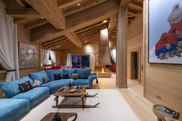 A living room with a blue couch and a painting on the wall