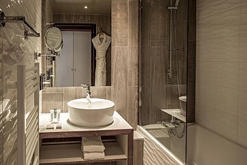 A bathroom with a sink a mirror and a bathtub