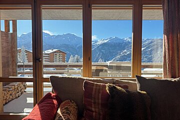 A living room with a view of snowy mountains