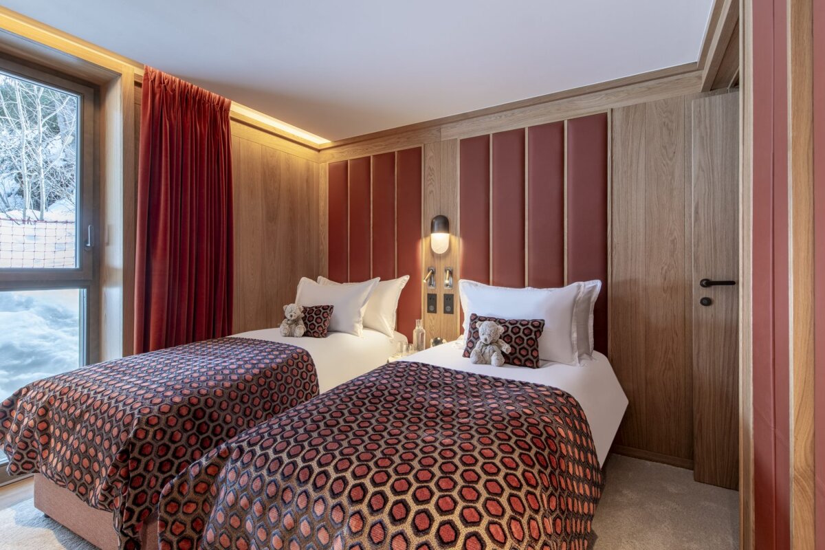 A bedroom with two twin beds and a window