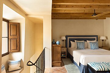 A bedroom with a blue headboard and blue pillows