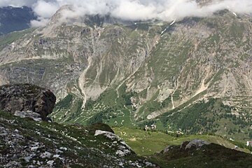 a green valley below a hiking trail in val disere