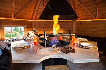 A table with plates and candles and a fire coming out of it
