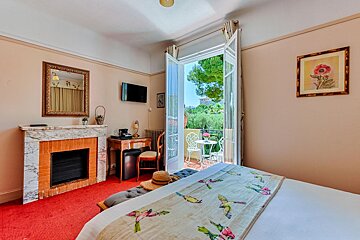 A hotel room with a fireplace and a balcony