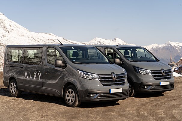 Two alpy vans are parked next to each other